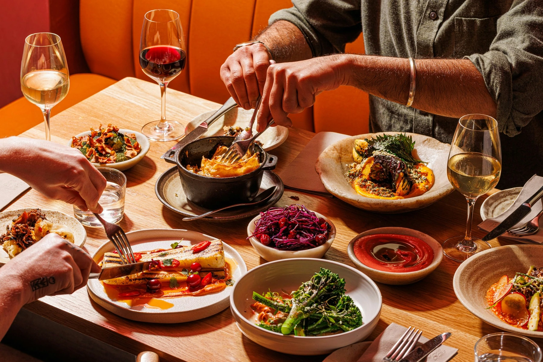Friends sharing vibrant dishes around a restaurant table